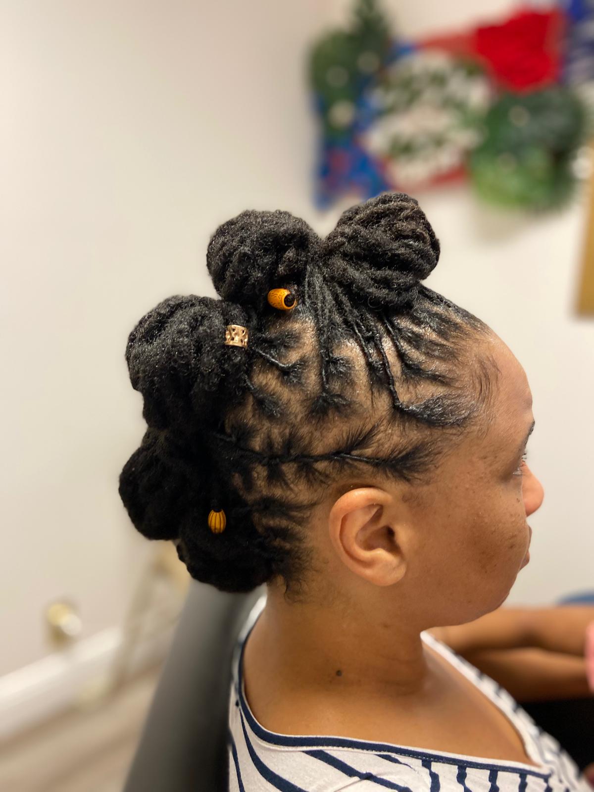 Sophisticated crown loc updo adorned with golden decorative pins perfect for special occasions