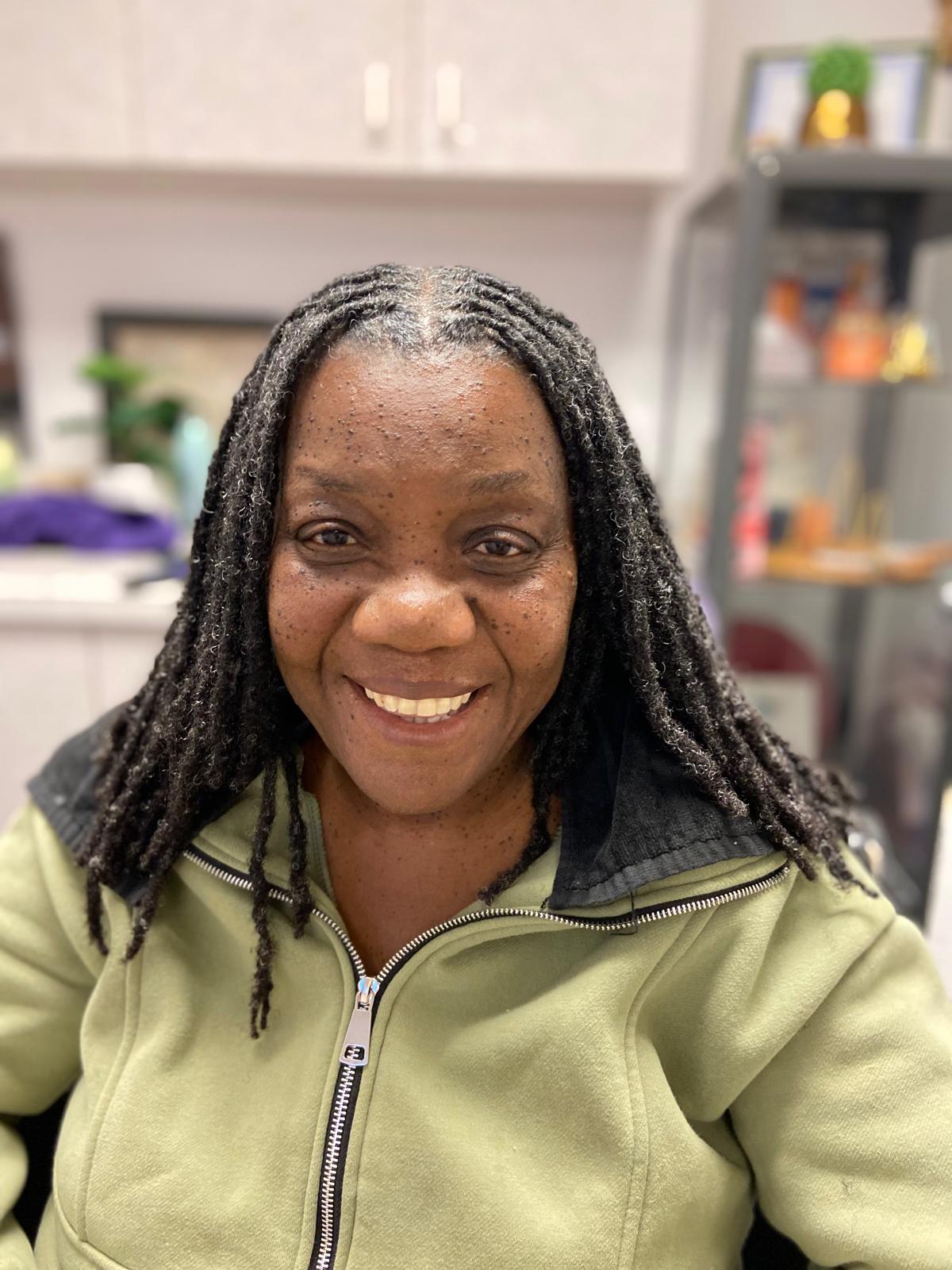 Joyful mature woman with beautiful shoulder-length crown locs radiating satisfaction