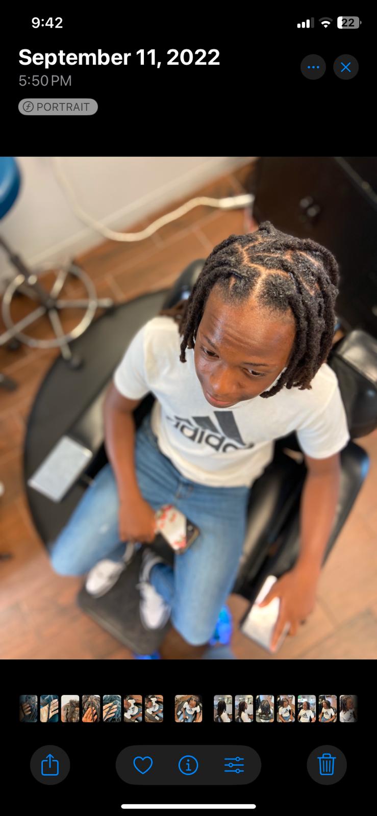 Young client with freshly completed crown locs showing family-friendly services and confidence